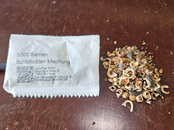 Weiße Saatgut-Tüte mit Direktdruck-Logo und daneben eine kleine Portion Samen